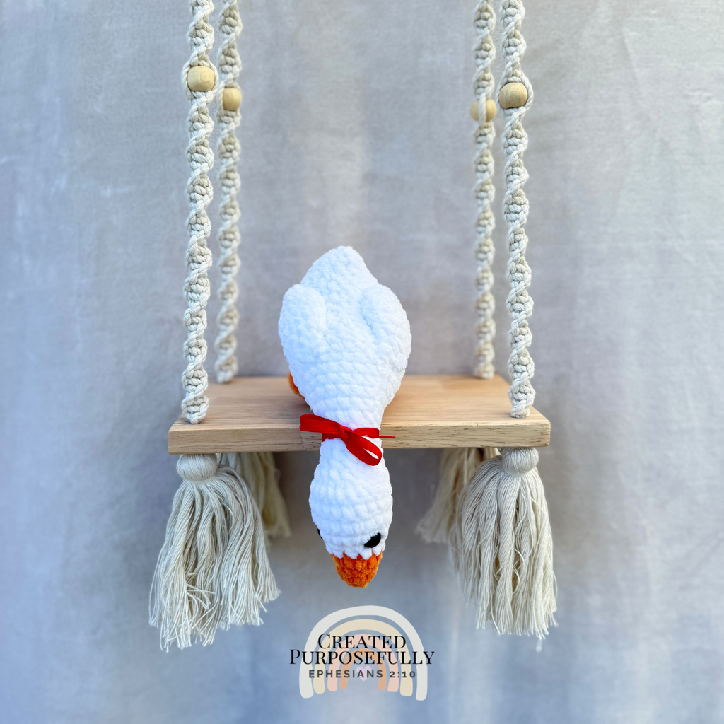 Handmade crochet shelf goose plush in a looking-down pose sitting on the edge of a shelf by Created Purposefully