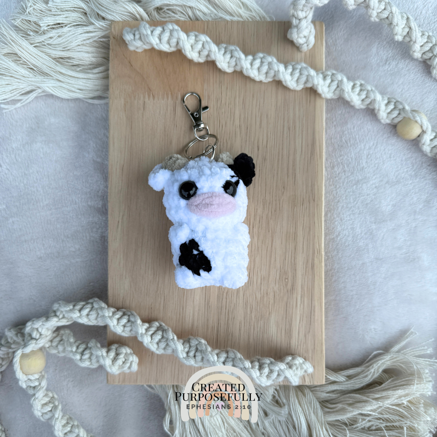Handmade crochet cow backpack buddy keychain in multiple colors, made with soft plush yarn for backpacks, purses, keys, and gifts.