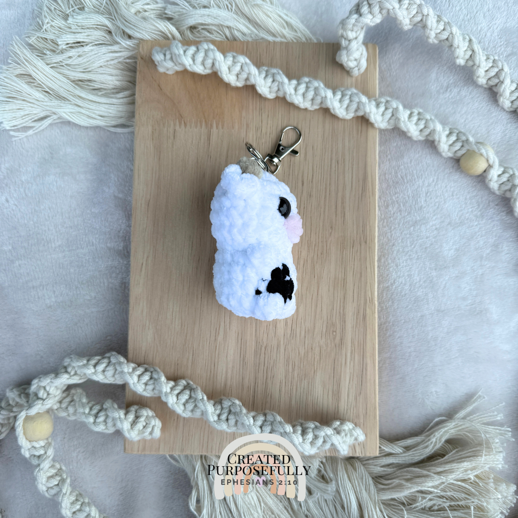 Handmade crochet cow backpack buddy keychain in multiple colors, made with soft plush yarn for backpacks, purses, keys, and gifts.