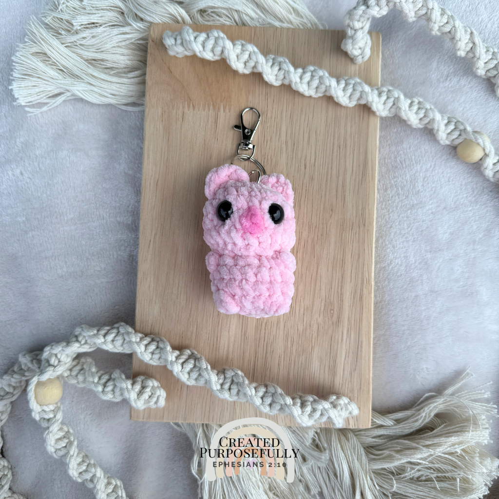 Handmade crochet pig backpack buddy keychain made with soft plush yarn, a cute bag charm for backpacks, purses, keys, and gifts.