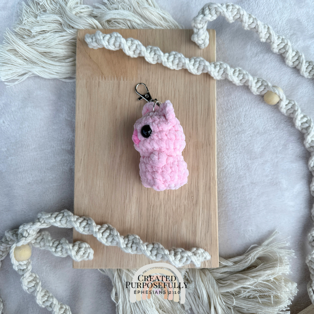 Handmade crochet pig backpack buddy keychain made with soft plush yarn, a cute bag charm for backpacks, purses, keys, and gifts.