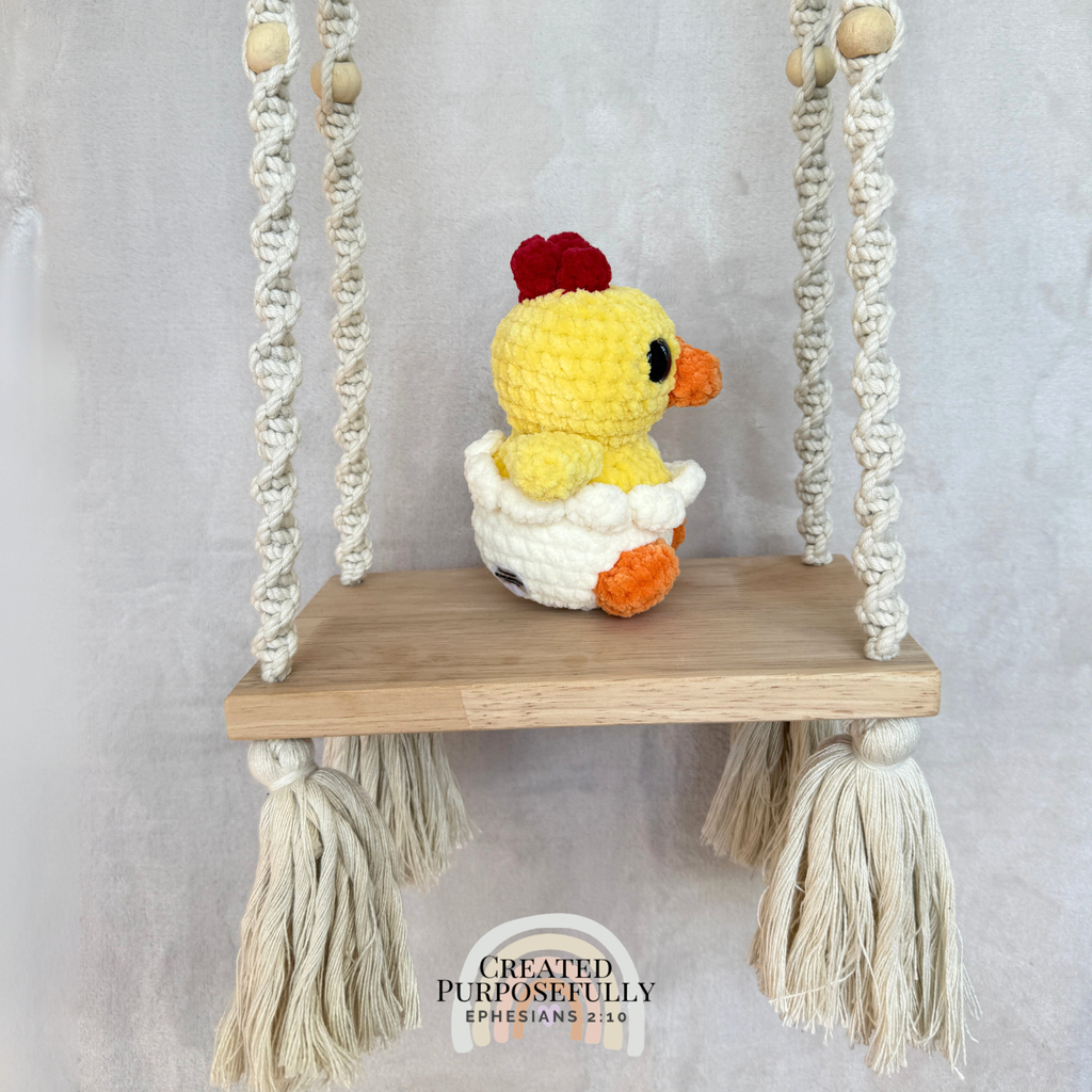 Handmade hatching chick crochet plush peeking from an eggshell made with soft plush yarn