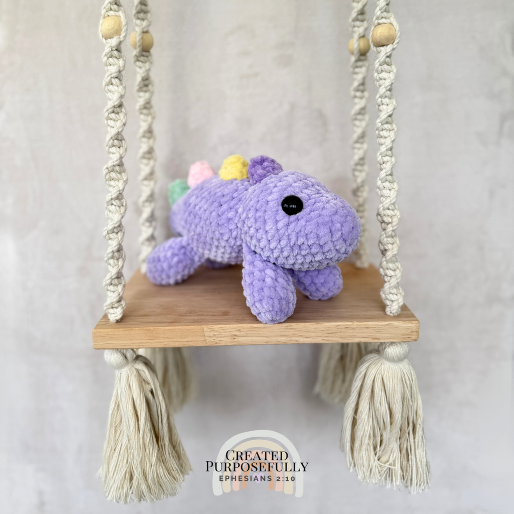 Handmade laying stegosaurus plush made with soft plush yarn and adorable dinosaur details