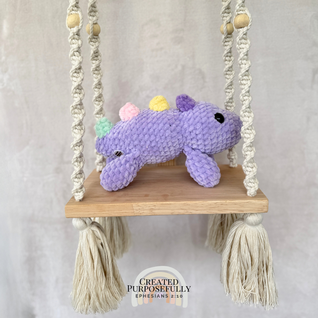Handmade laying stegosaurus plush made with soft plush yarn and adorable dinosaur details