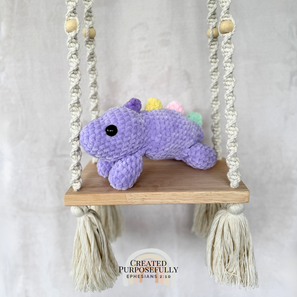 Handmade laying stegosaurus plush made with soft plush yarn and adorable dinosaur details