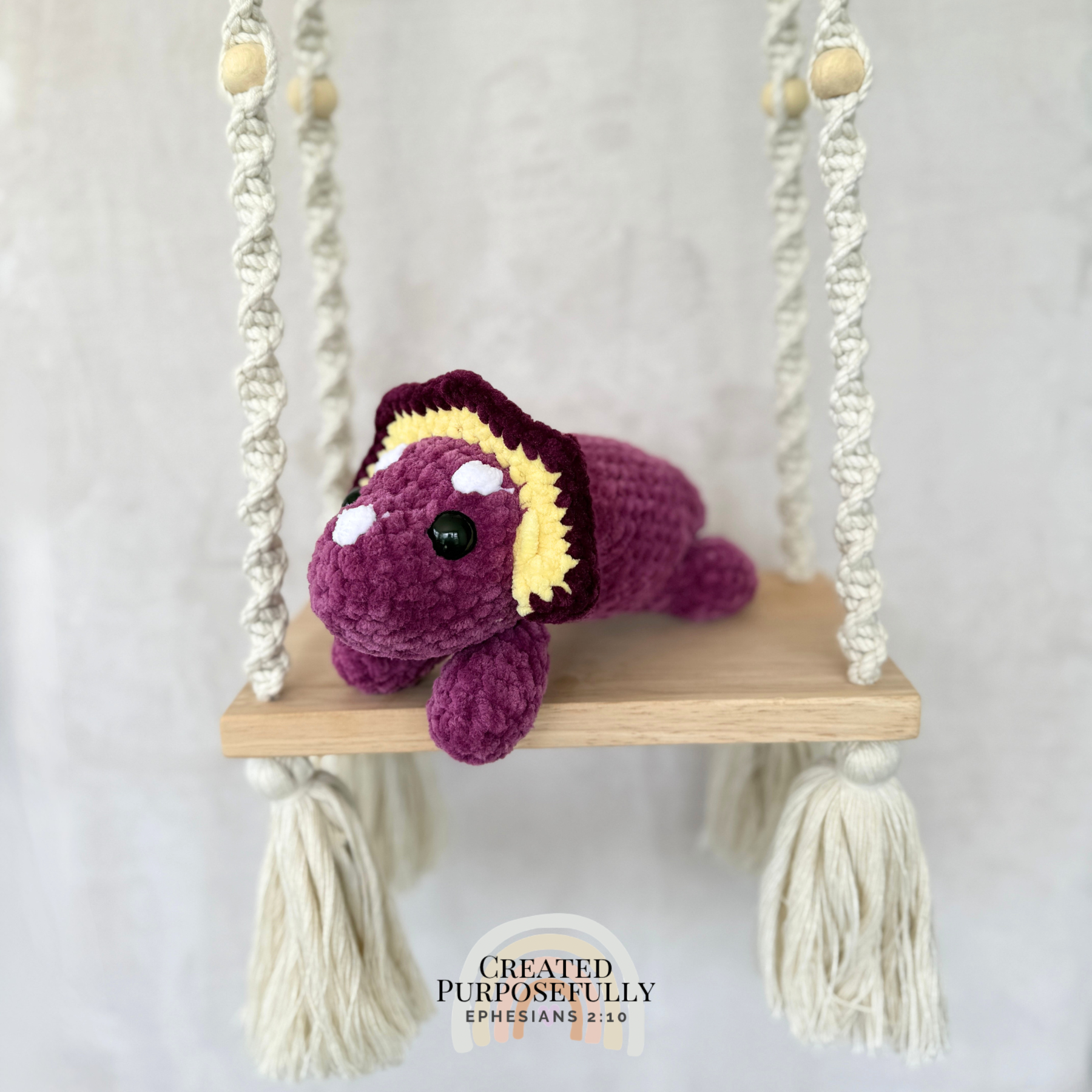 Handmade laying triceratops plush made with soft plush yarn and adorable dinosaur details