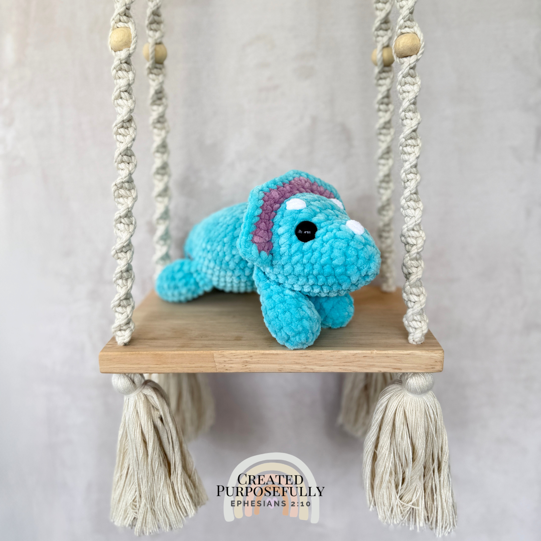 Handmade laying triceratops plush made with soft plush yarn and adorable dinosaur details