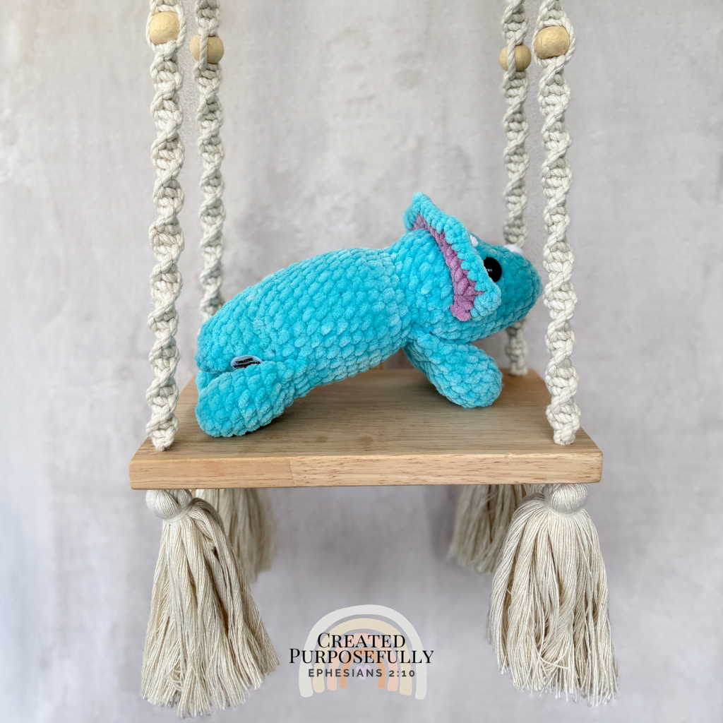 Handmade laying triceratops plush made with soft plush yarn and adorable dinosaur details