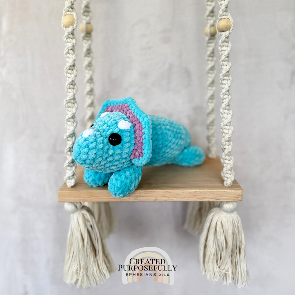 Handmade laying triceratops plush made with soft plush yarn and adorable dinosaur details
