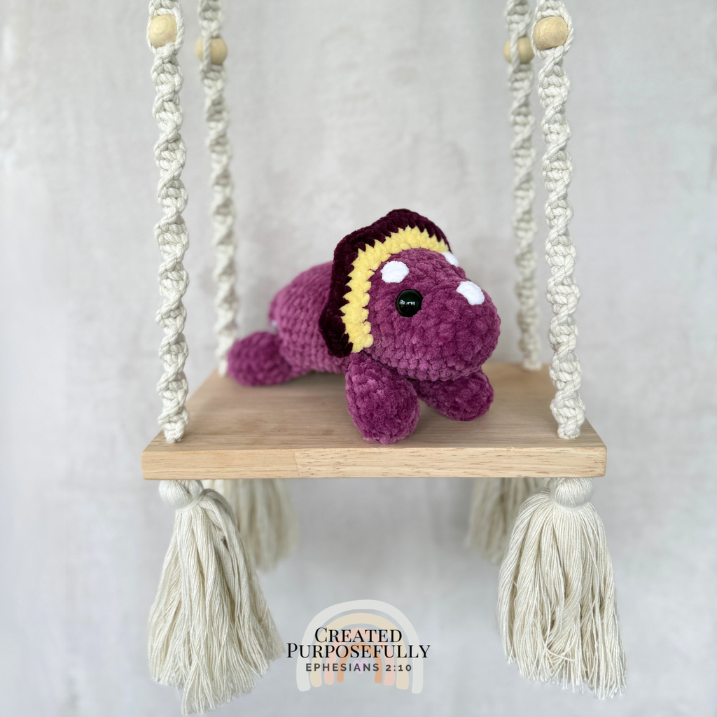 Handmade laying triceratops plush made with soft plush yarn and adorable dinosaur details