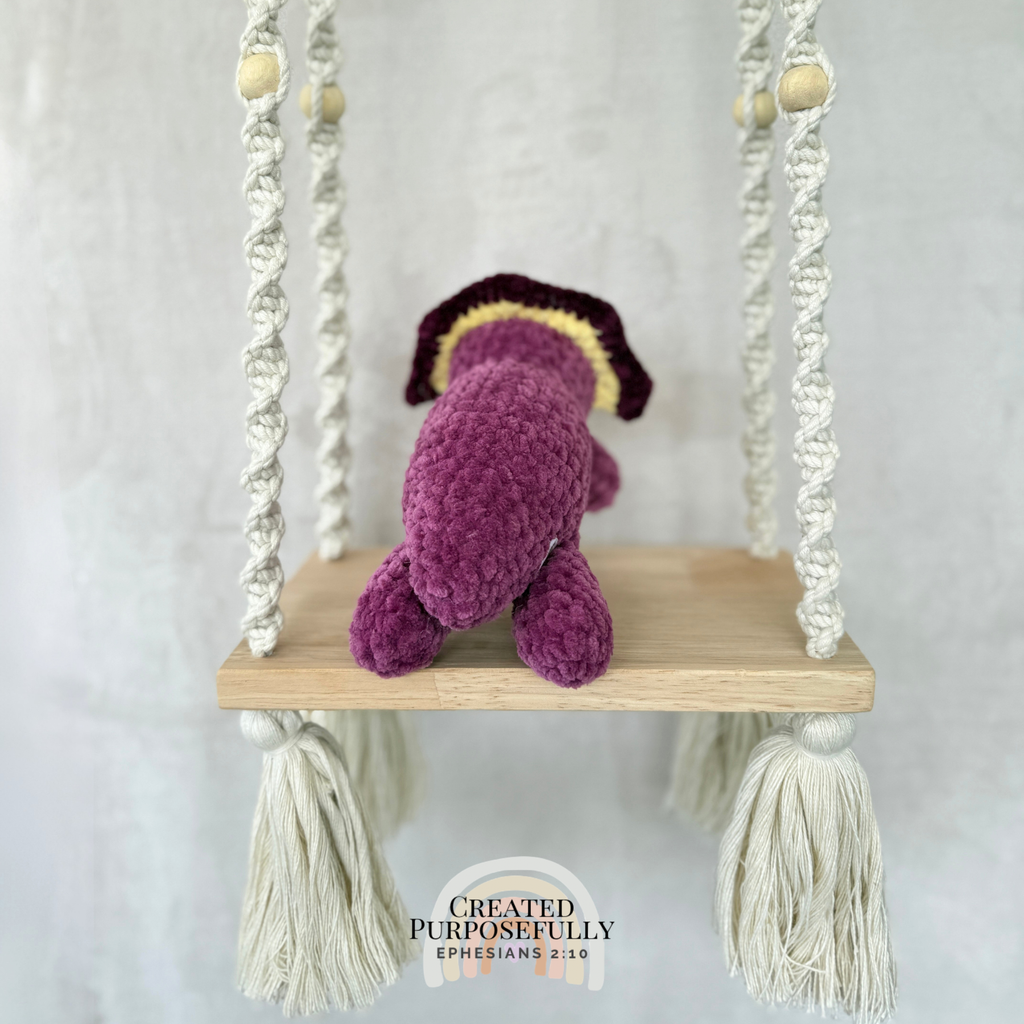 Handmade laying triceratops plush made with soft plush yarn and adorable dinosaur details