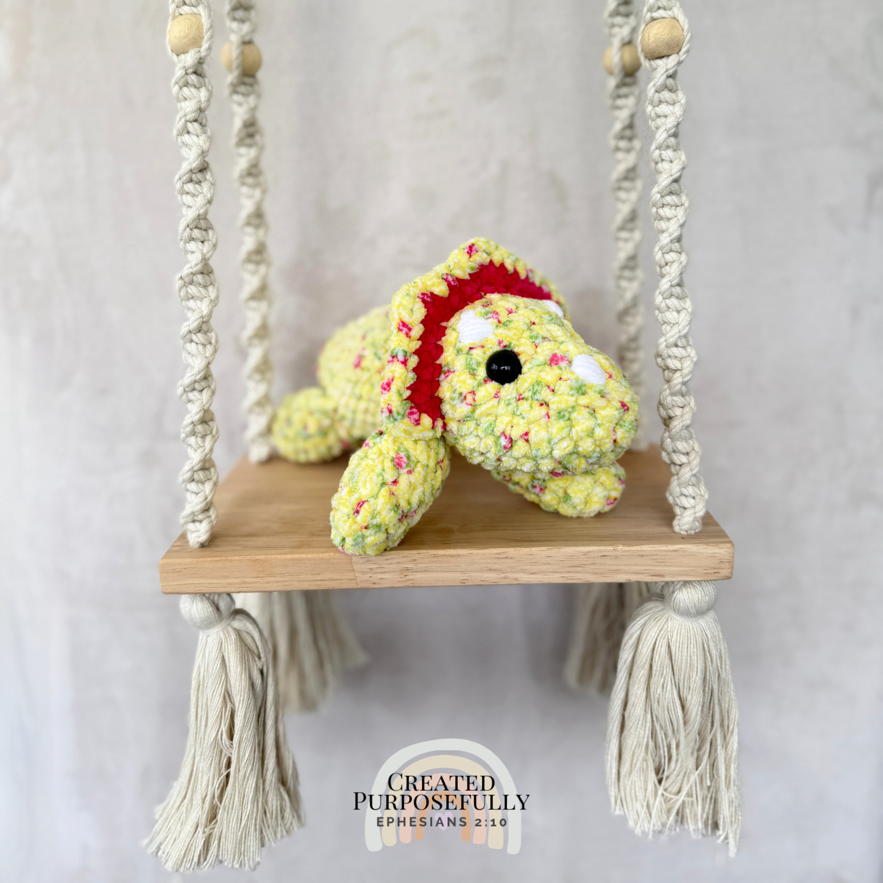 Handmade laying triceratops plush made with soft plush yarn and adorable dinosaur details