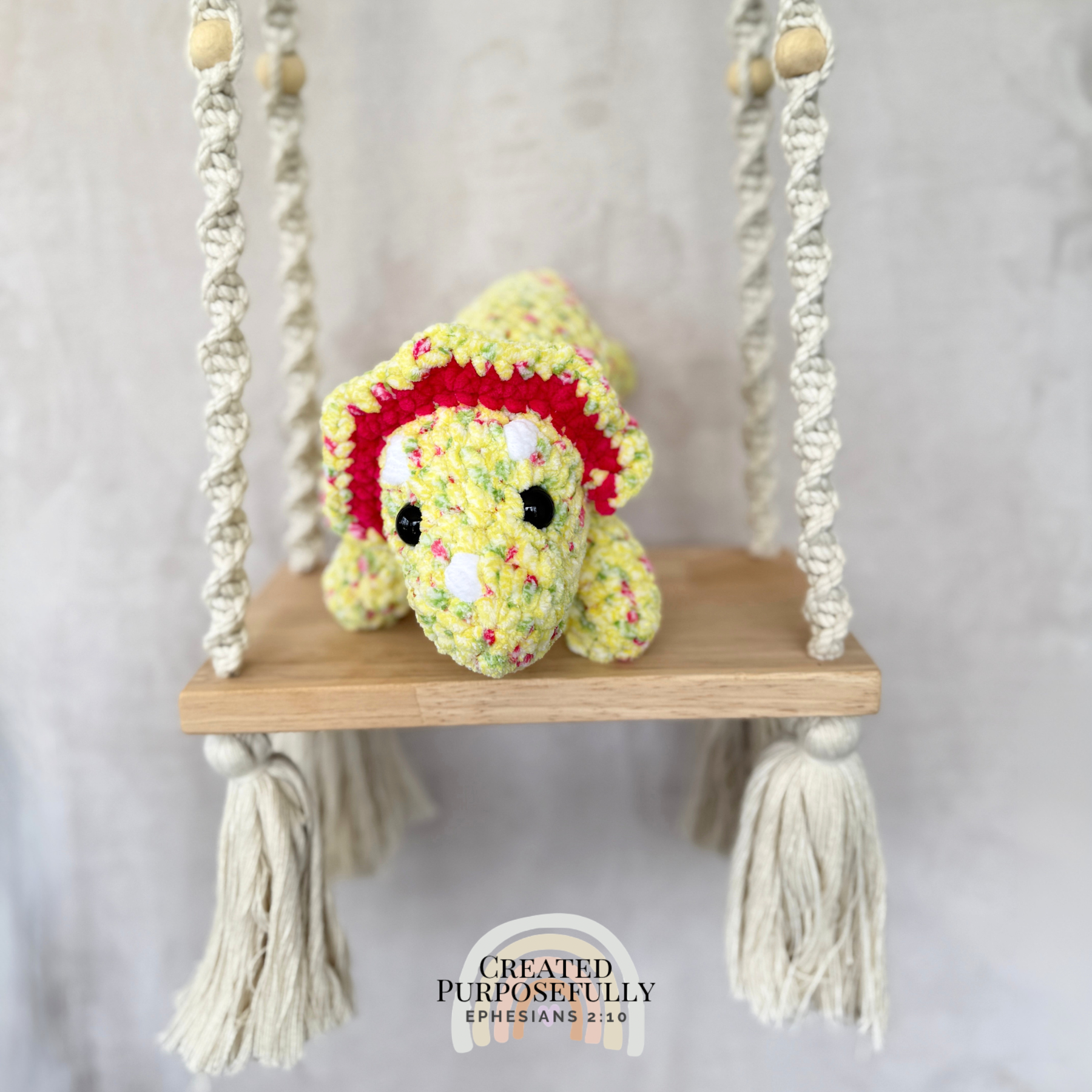 Handmade laying triceratops plush made with soft plush yarn and adorable dinosaur details